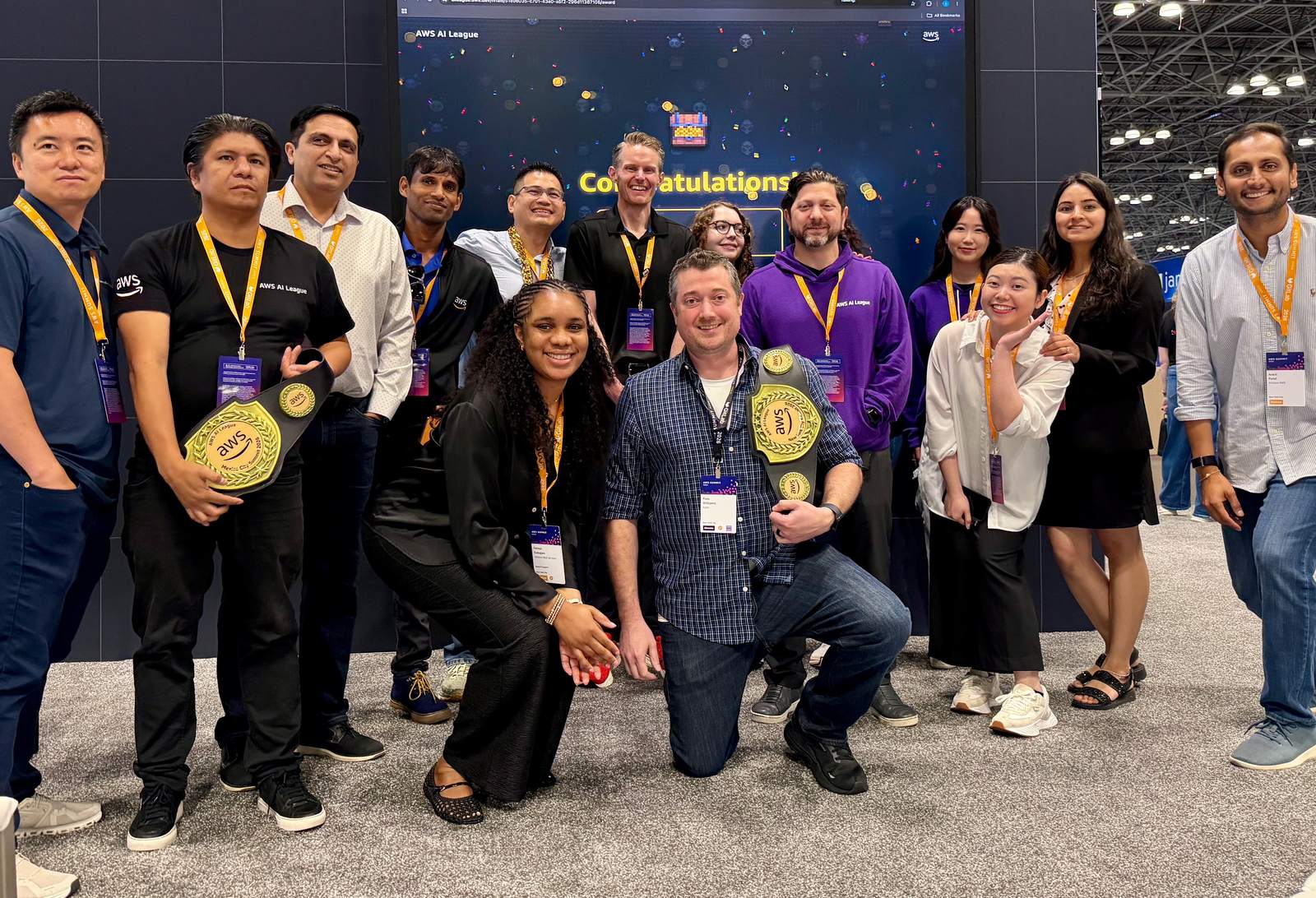 Group photo of the author with the AWS team who ran the AI League at the Summit, in front of the congratulations screen