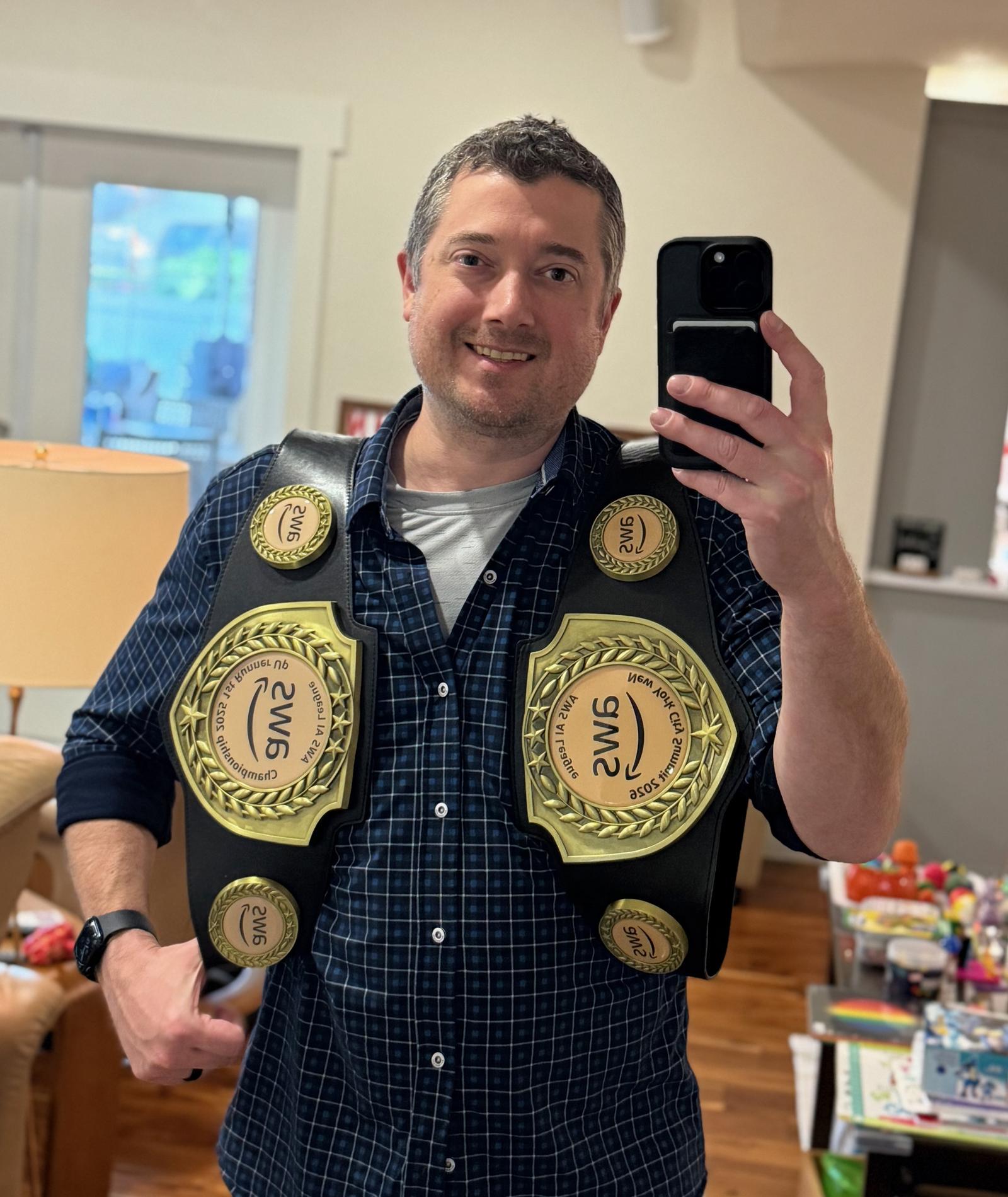 The author at home wearing two AWS AI League championship belts